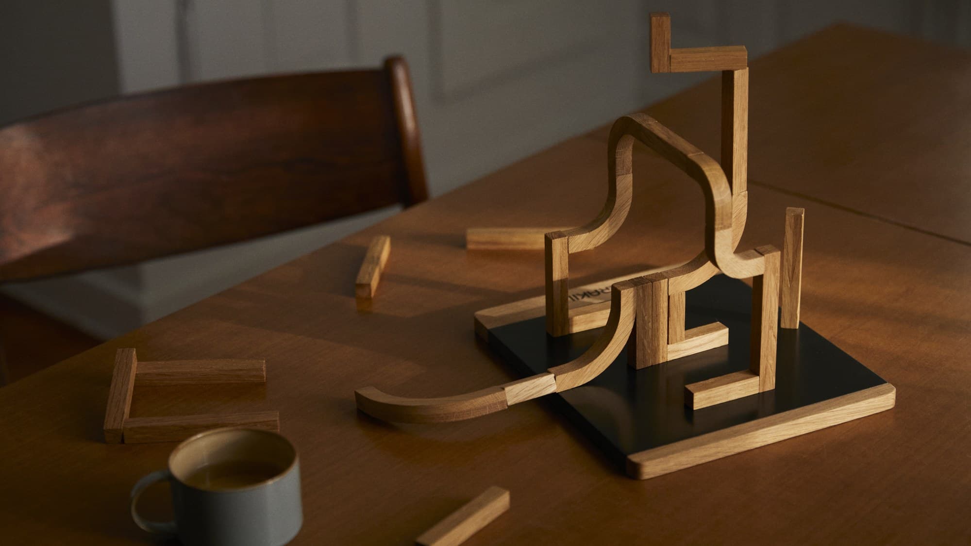 A tall MERAKII structure on a dining table in warm evening light